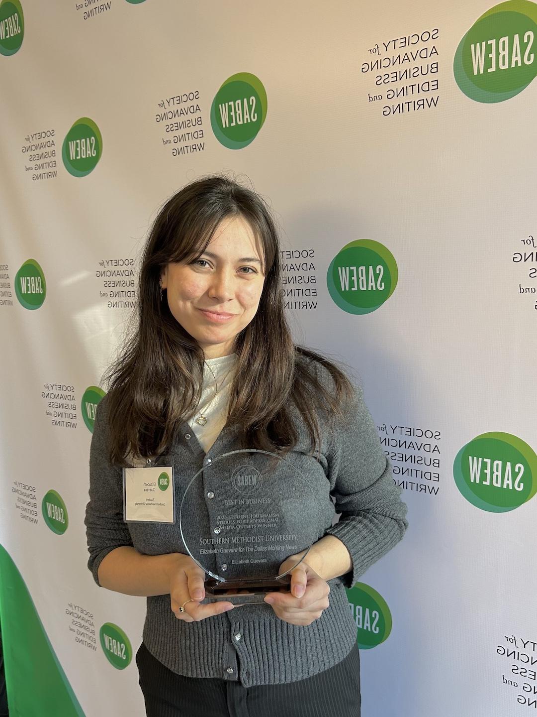 Senior Elizabeth Guevara poses with her award for student business reporting at the Society for Advancing Business Editing and Writing conference.